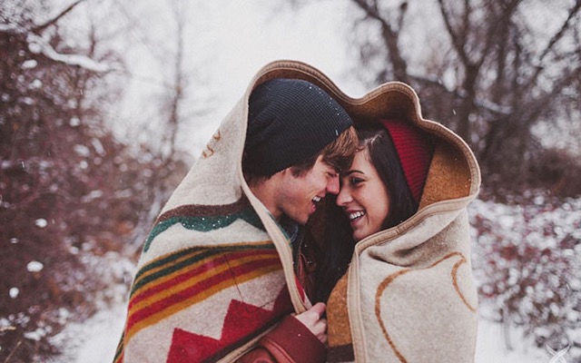 couples with blanket on snow