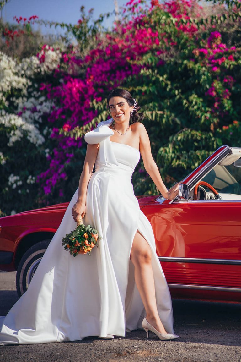 Bride next to red old car